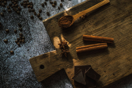 coffee, dark chocolate, cinnamon sticks and spices on a brown wooden board 1の写真素材