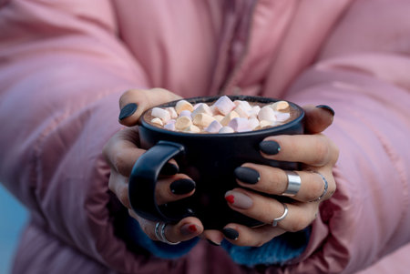 a girl in pink holds a cup of marshmallow in her handsの写真素材