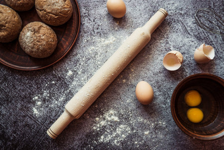 ingredients for baking rye buns, rolling pin, eggs, flour, mixer on gray background 1
