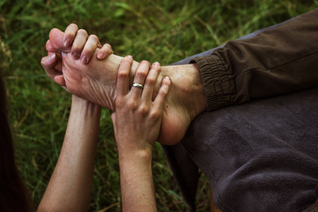 girl makes a foot massage to a guy in nature 1の写真素材
