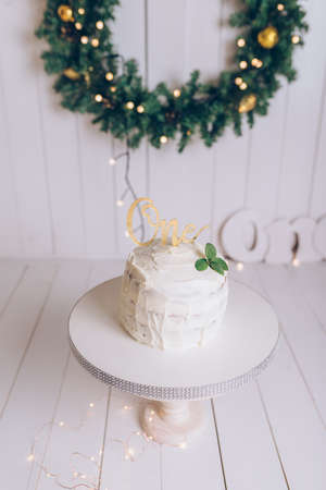 One year cakesmash party white cake with mint and golden letters on light wooden backgroundの写真素材