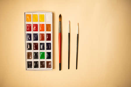 new Watercolor paints with brushes on yellow backgroundの写真素材