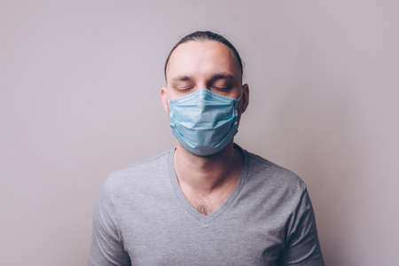 Young man in a medicine mask with closed eyesの写真素材