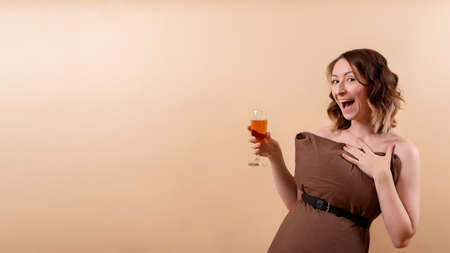 Happy and cheerful cute girl smiling and holding aperol cocktail in her hand. Pillow challenge conception bannerの写真素材