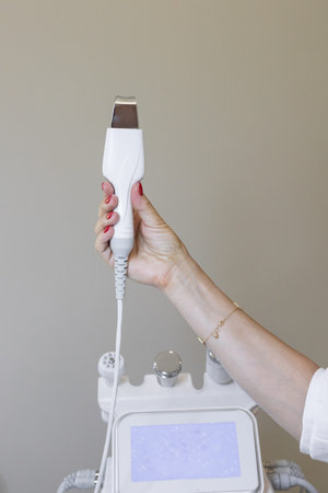 Close-up. Cosmetology procedure in beauty studio. Ultra sonic scrubber for face cleansing, acne...