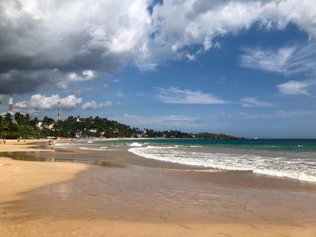 Tropical exotic paradise in Sri Lanka, ocean cost with palms hanging over the beach, blue sky and water, wellnes and relaxation viewの写真素材
