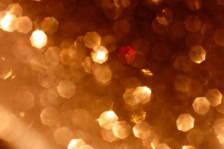 Abstract glitter lights textured golden and white dark background, de-focused, bokeh. Christmas or New Year festive blured sparkling background, winter holidays card conceptの写真素材