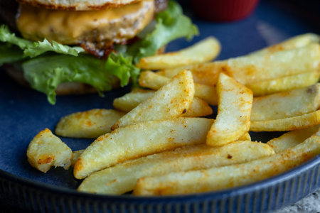 A delicious cheeseburger sits on a blue plate, topped with fresh lettuce and a slice of cheese....