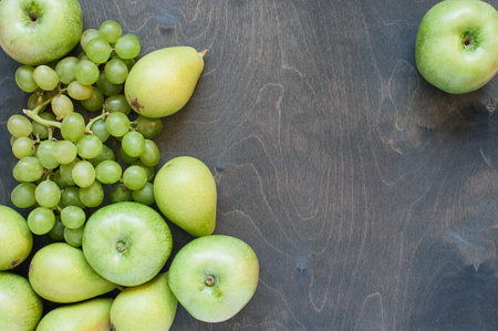 Green fruits on a background of dark woodの写真素材