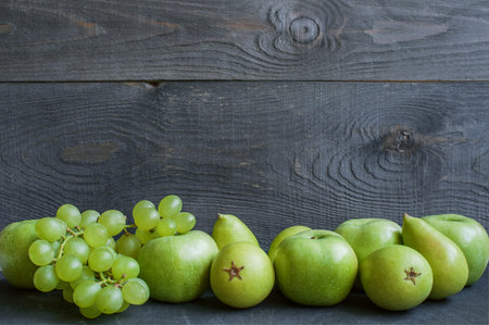 Green fruits on a background of dark woodの写真素材