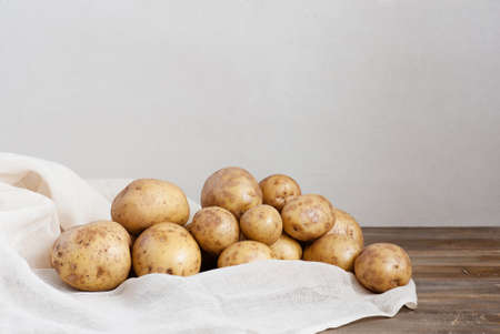 Fresh potatoes on the old wooden tableの写真素材