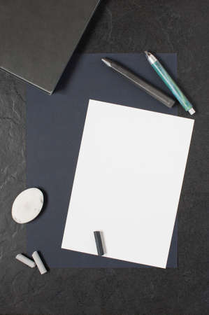 Sheet of paper and painting supplies on the dark tableの写真素材