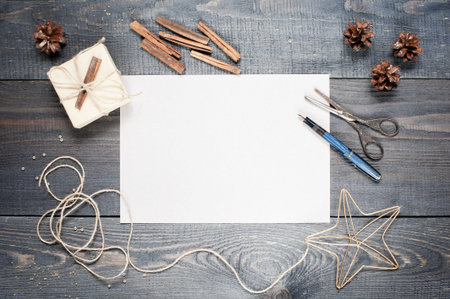 Blank sheet of paper with composition on the dark wooden textured tableの写真素材