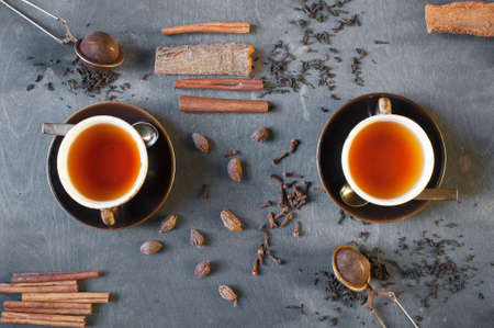 Two cups of tea with spices on the wooden tableの写真素材