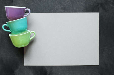 Blank sheet of paper and vintage cups on the wooden tableの写真素材