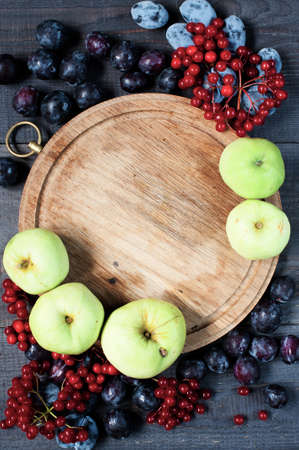 Old board, plums, viburnum, and apples backgroundの写真素材