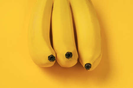 Three ripe bananas on the yellow backgroundの写真素材