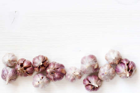 Whole heads of garlic on the white wooden tableの写真素材