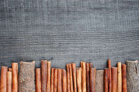 Wooden background with cinnamon sticksの写真素材