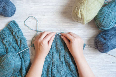 Woman's hands knitting the blue scarfの写真素材