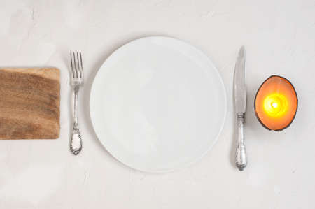 Serving table with empty plate and candleの写真素材