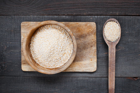 Oat bran in the wooden bowl on the dark tableの写真素材
