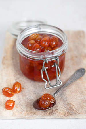 Goosberry jam in the glass jar in the tableの写真素材