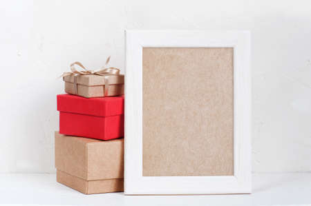 Empty frame and various gift boxes on the white table, mock-upの写真素材