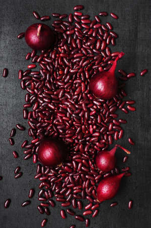 Red beans and onion scattered on the black tableの写真素材