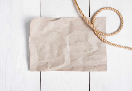 Empty sheet of paper and rope on the wite wooden tableの写真素材