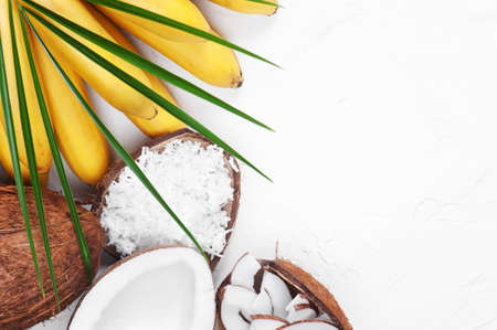 White background whith bananas, coconuts and palm leafの写真素材