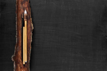 Black wooden background with Chinese paint brushesの写真素材