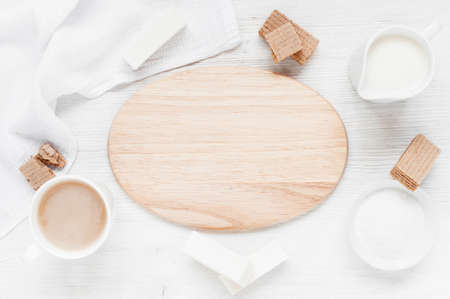 Background with empty board, tea with milk l and pastry in the light colorsの写真素材
