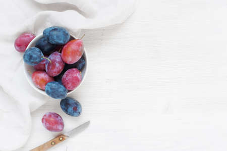 Wooden background with plums and white towelの写真素材