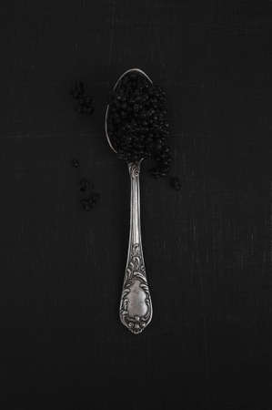 Black caviar in the silver spoon lies on the dark tableの写真素材