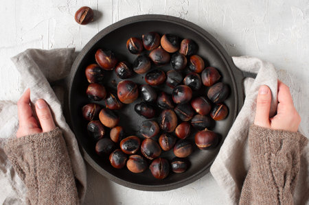 Woman holding the pan with roasted chestnutsの写真素材