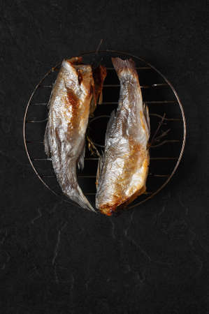 Fried fish on the black stone tableの写真素材