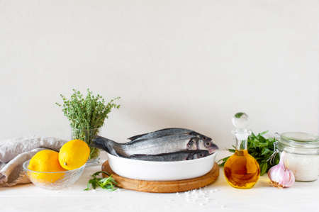 Raw fresh fish an ingredients on the white wooden table. Composition with copy spaceの写真素材