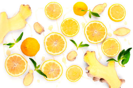 Ingredients for vitamin winter drink - cut ginger with slices of lemons and mint, honeyedの写真素材