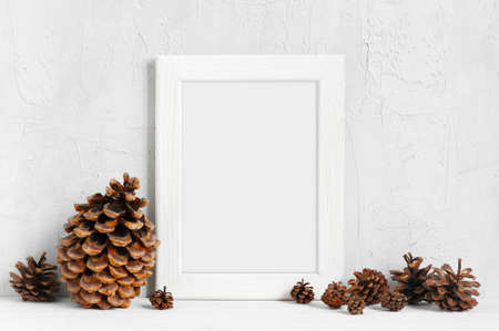 White wooden frame and various pine cones on the tableの写真素材
