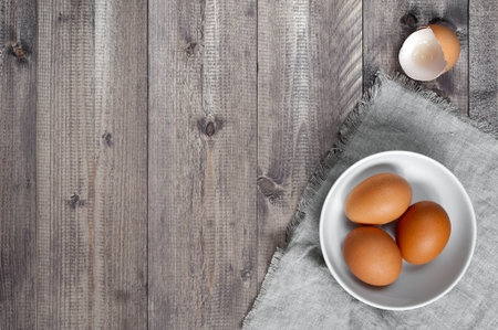 Wooden background with fresh raw eggs. Top view and empty space