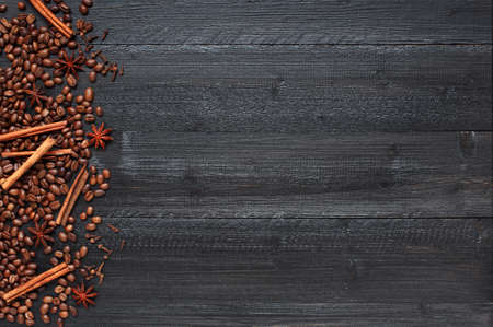 Wooden background with coffee beans and oriental spices. Black textured table with decoration and empty spaceの写真素材