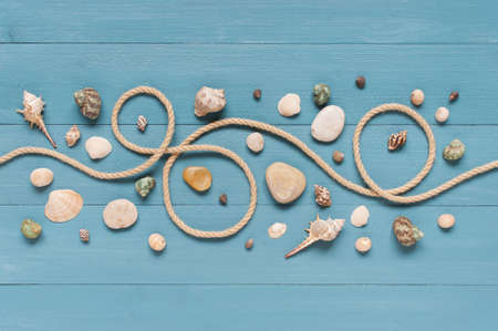 Blue wooden boards decorated with rope, shells and pabbleの写真素材