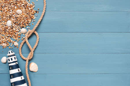 Blue wooden background with lighthouse, rope and pebbleの写真素材