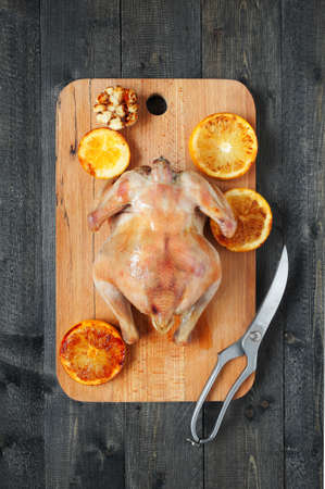 Grilled chicken with oranges and kitcen scissorsの写真素材