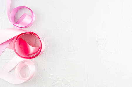 White textured background with pink satin ribbons, copy spaceの写真素材