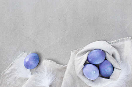 Gray Easter background with lilac spotted eggs on the textured gray table. Copy spaceの写真素材