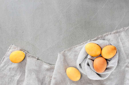 Gray Easter background with yellow bright eggs on the textured gray table. Copy spaceの写真素材