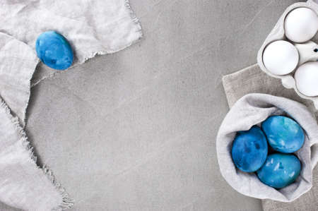 Gray Easter background with blue bright eggs on the textured gray table. Copy spaceの写真素材