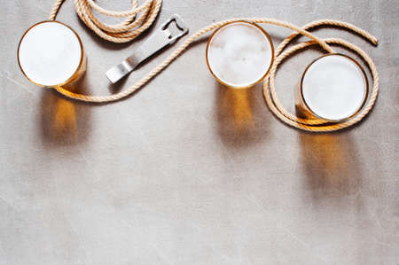 Background with three glasses of light beer and rope on the stone table, top view の写真素材